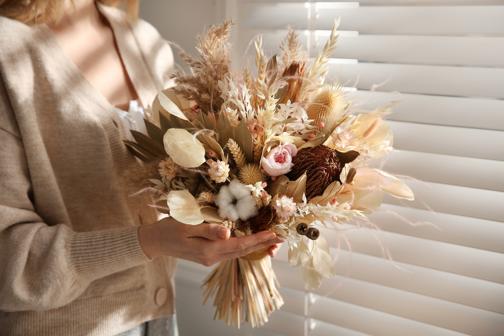 Woman,Holding,Beautiful,Dried,Flower,Bouquet,Near,Window,At,Home,